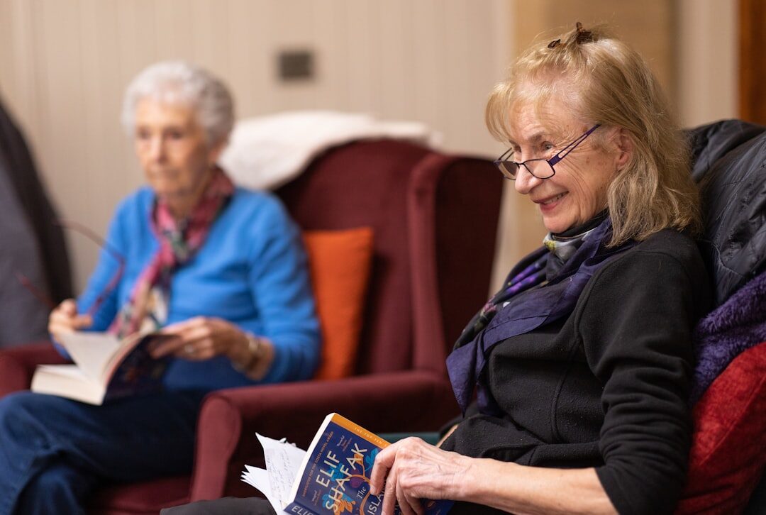 Seniors gathered in a circle discussing a book during a book club meeting